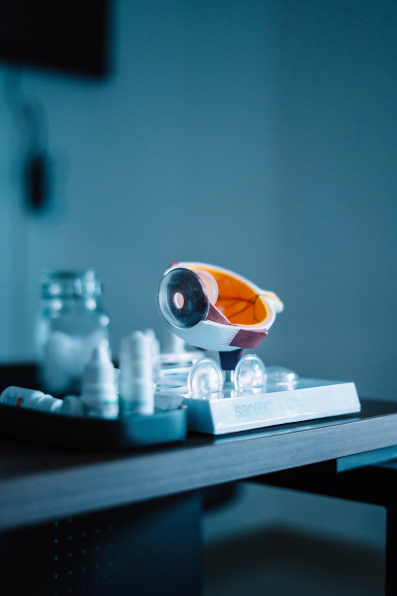 A close-up of a colorful model cart sitting on a table, surrounded by medical supplies like bottles and jars, highlighting a healthcare context.